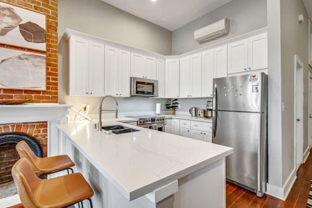 Bright white kitchen w/ bar area — great for cooking in or grabbing a quick bite.