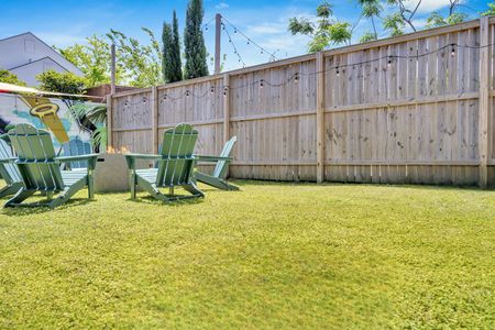 Backyard w/ firepit, green seating, & plenty of room to unwind under the open sky.