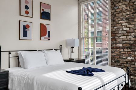 Airy bedroom bathed in natural light w/ crisp white bedding.