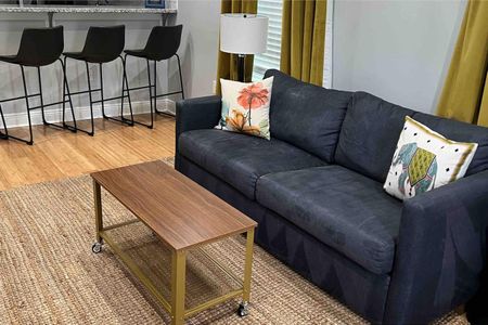 Cozy living room w/ plush sofa & wood coffee table — perfect for unwinding after a long day.