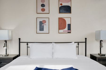 Classic black bed frame w/ curated wall art for a stylish night's sleep.