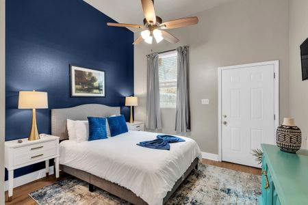 Bright bedroom w/ crisp white bedding & warm natural light.