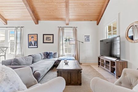 Bright living room w/ large couch & two chairs — plenty of seating for the whole group.