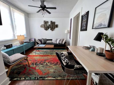 Light-filled living room w/ colorful rug & cozy seating — perfect for unwinding after a day out.