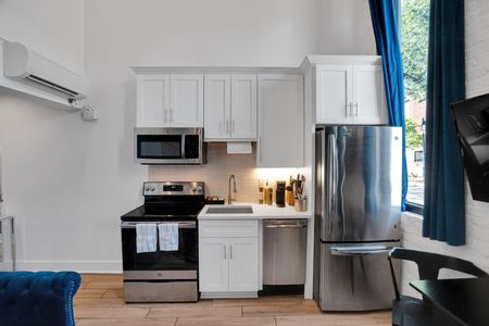 Bright, well-equipped kitchen w/ stainless steel appliances & classic white cabinetry.