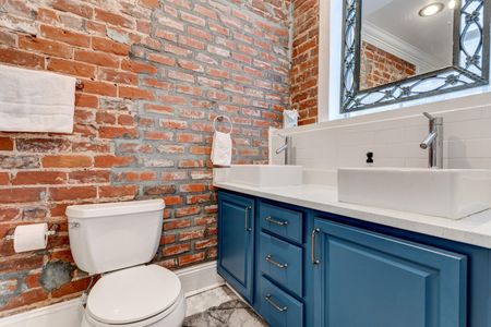 Bright bathroom vanity w/ sink & sleek blue cabinetry.