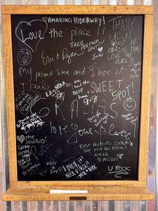 Chalkboard wall covered in guest notes & doodles — leave your own mark.