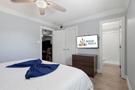Unwind in a cozy bedroom w/ soft bedding & a wall-mounted TV.
