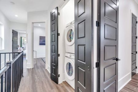 Upstairs washer & dryer tucked neatly behind sleek black doors — so convenient.