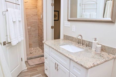 Freshen up in the master bathroom w/ a sink & warm stone finishes.