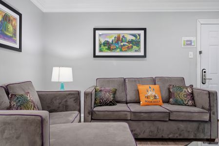 Cozy living nook w/ soft seating & cheerful artwork.