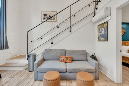 Relax in this stylish living area with modern decor, a comfy loveseat, and chic accents—perfect for unwinding after a day in the city.
