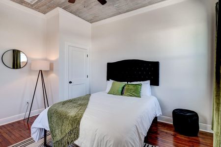 Cozy bedroom w/ a bed framed by clean white walls & natural light.
