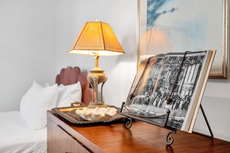 Cozy bedside setup w/ a warm lamp & a stack of curated books.