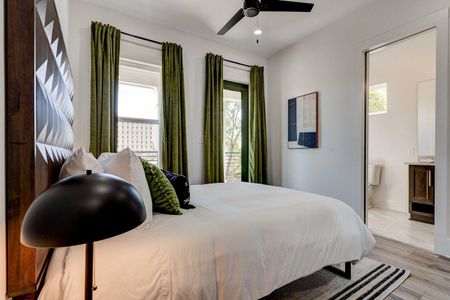 Upstairs bedroom w/ lush green curtains, warm tones & a relaxed vibe.