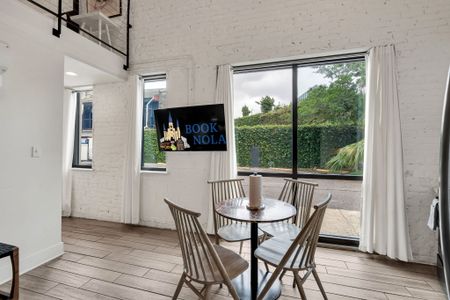 Charm meets natural radiance as the living room’s expansive windows invite the essence of New Orleans right inside (unit 2)