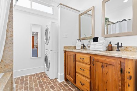 Clean bathroom w/ warm wood vanity & ample counter space for getting ready.