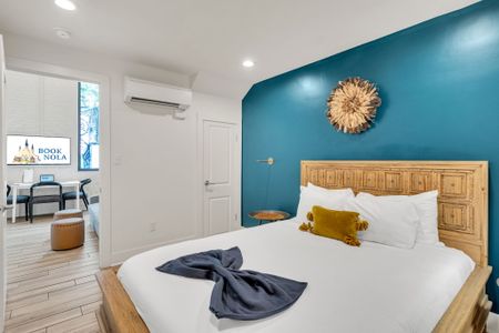 Unwind in a stylish bedroom with a comfy king bed, bold accent wall, and warm natural light. Perfect for couples or solo travelers looking for a relaxing stay near all the New Orleans action.