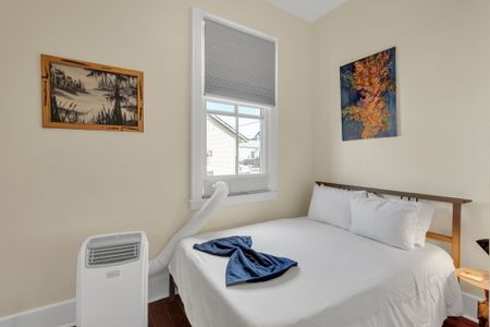 Softly styled bedroom w/ calming tones & cozy linens for a restful stay.