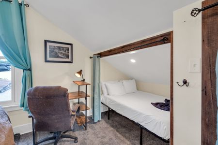 Clean, simply styled bedroom w/ a classic headboard & soft natural light.