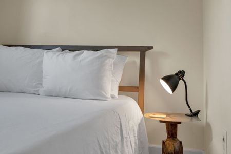 Softly lit bedroom w/ a plush bed & warm, inviting linens.