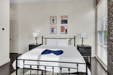 Sprawling bed dressed in crisp white linens w/ a bold modern headboard.