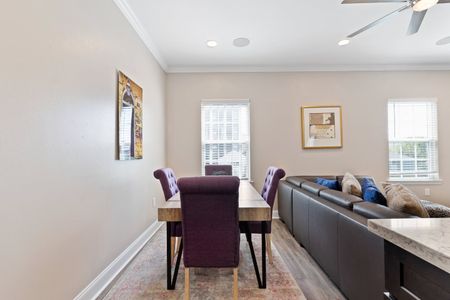 Dining table tucked behind the couch — seats 4 for easy meals together.