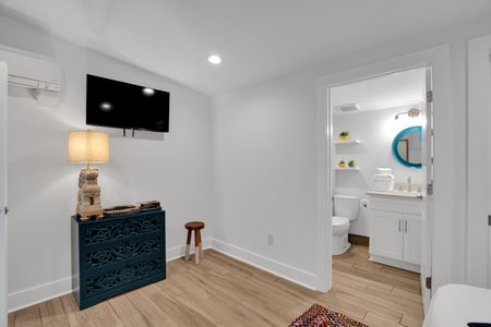 Bedroom 2 w/ a wall-mounted TV & clean white walls for a calm, comfortable stay.