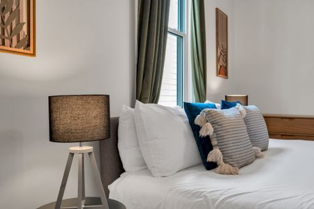 Bed dressed in soft, layered pillows & crisp linens for a boutique-hotel feel.