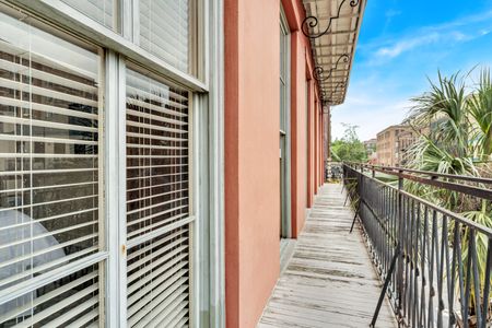 Private balcony w/ wrought-iron railings & lush palm tree views.