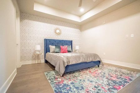 Cozy bedroom w/ a blue upholstered bed & soft, inviting linens.