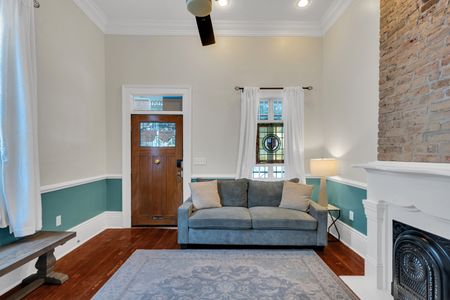 Bright living room w/ a sofa, teal walls & a welcoming, cozy vibe.