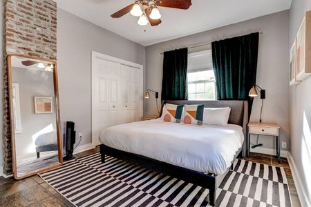 Serene master bedroom w/ crisp white bedding & vibrant teal curtains.