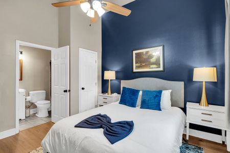 Bedroom w/ navy accent wall, plush pillows & ensuite access for added privacy.