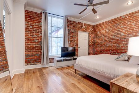 Sun-lit bedroom corner w/ exposed brick & a peaceful, airy feel.