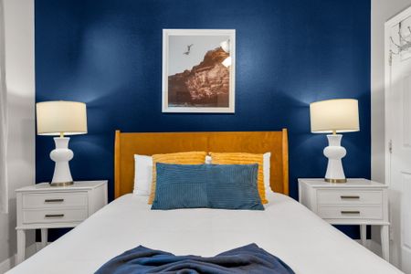 Bold navy & gold bedroom w/ a plush bed & rich accent wall.