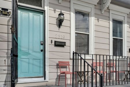 Welcoming teal front door w/ a classic exterior — a charming first impression.