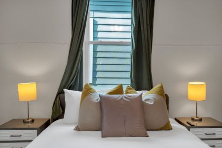 Dreamy window seat bathed in soft natural light w/ lush curtains framing the view.