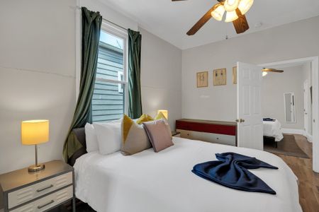 Cozy bed dressed in soft layers w/ thoughtful accent pillows & warm lighting nearby.