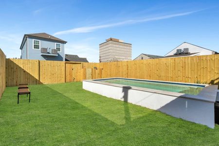 Fully-fenced pool w/ lush green lawn surrounding it — plenty of space to relax outside.