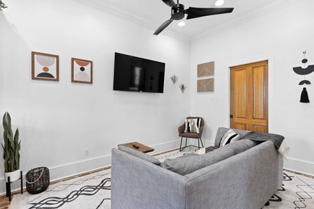 Clean, bright living area w/ wall-mounted TV — laid-back comfort awaits.