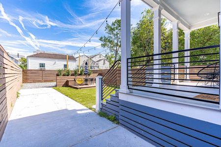 Covered rear porch w/ deck seating & a spacious backyard to unwind.