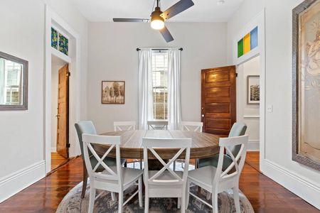 Sun-lit dining nook w/ an 8-seat table & wood accents — perfect for shared meals.