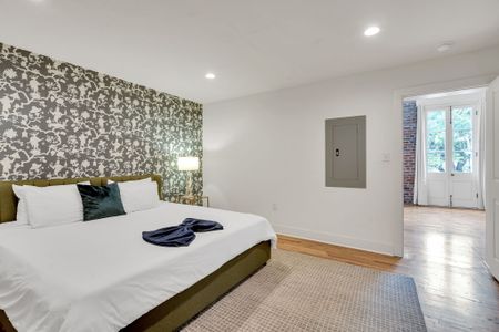 Sink into soft, stylish comfort in the cozy bedroom featuring a king-size bed, warm lighting, and calming tones—your personal retreat after exploring the city