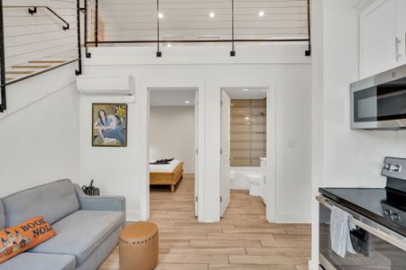 Enjoy a fully equipped kitchen, sleek loft vibes, and easy access to the bedroom and bathroom—all in a well-lit, airy setting.