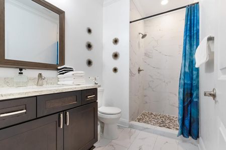 Bathroom w/ dark wood vanity & modern fixtures.