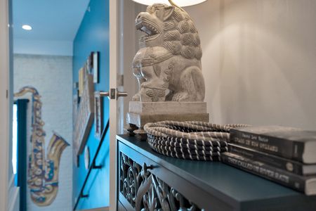 Striking stone lion sculpture brings cultural depth & artistic weight to the décor.