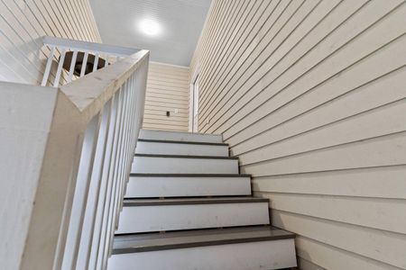 Bright staircase w/ white walls — clean, airy & easy to navigate.