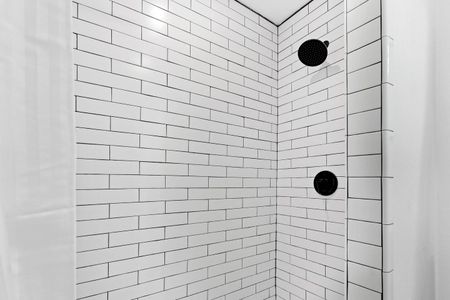 Sleek tiled shower w/ modern fixtures — clean & refreshing.