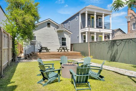 Bright backyard hangout w/ firepit, Adirondack chairs, & sunny NOLA skies overhead.